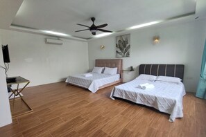 A hotel room with two beds, a ceiling fan, an air conditioning unit, a painting on the wall, and a small table with a lamp. - Aeden Villa Roomstay & Homestay By Zuzu (Kuala Kangsar)