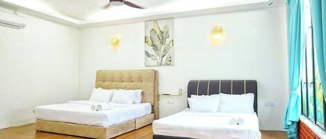 A hotel room with two beds, a ceiling fan, wall-mounted lights, and a window with curtains.