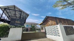 Una villa con un amplio espacio abierto, zona cubierta y acceso mediante portón.