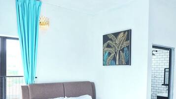 A modern bedroom with a bed, a ceiling fan, a window with curtains, and a wall-mounted artwork.