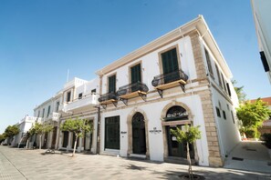 A white building with a barbershop sign, a visible entrance, and a small tree in front. - Kentrikon 1924 Boutique Hotel And Suites (Paphos)