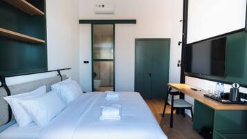 Ein Hotelzimmer mit Bett, Schreibtisch, Fernseher und Kleiderschrank.