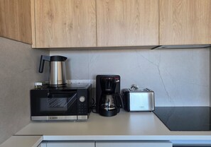 A kitchen with a microwave, coffee maker, and toaster on a countertop. - Kentrikon 1924 Boutique Hotel And Suites (Paphos)