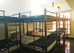A dormitory room with bunk beds, a window with bars, and a door. - Soloscape Stays Bengaluru (Bengaluru)