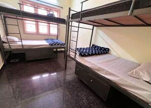 A dormitory room with bunk beds, a window, and a small desk. - Soloscape Stays Bengaluru (Bengaluru)
