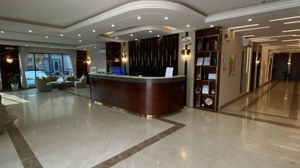 A hotel reception area with a reception desk, seating area, and a view of the street.