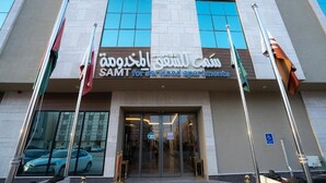 A building with a sign for 'SAMT for serviced apartments' and flags. - Samt Inn Al Narjis (Riyadh)