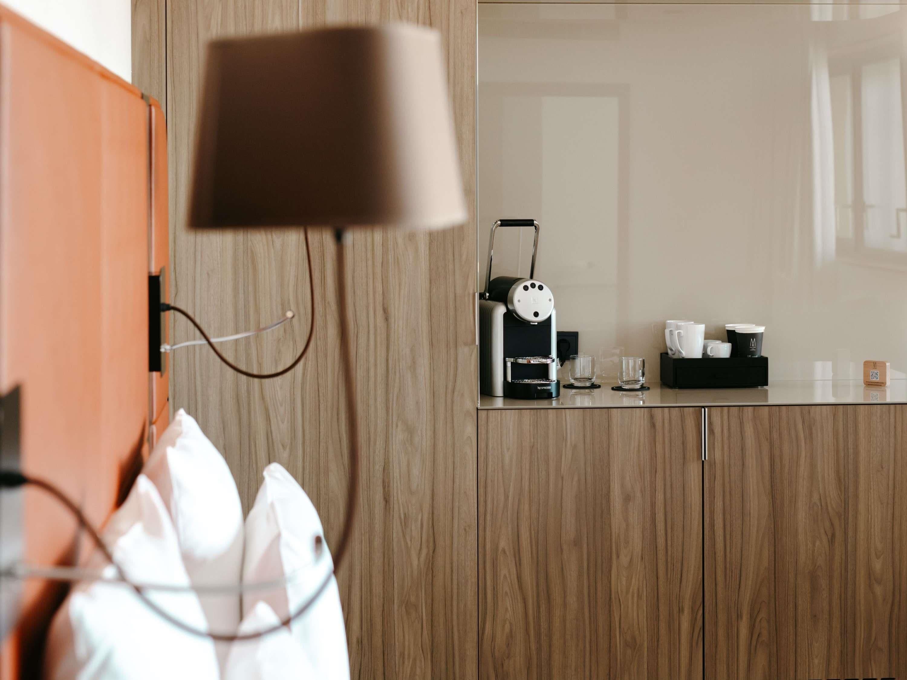 Une cuisine moderne équipée d’une machine à café, d’un comptoir en verre et d’un meuble en bois.