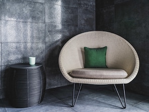 A wicker chair with a cushion and a small table beside it. - Sainte-barbe Hotel Spa Le Conquet-mgallery Collect (Le Conquet)
