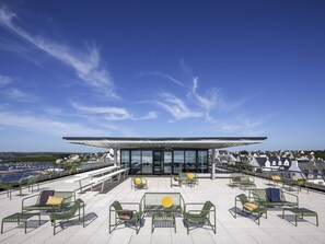 Una terraza en la azotea con mobiliario exterior y vistas a la ciudad.