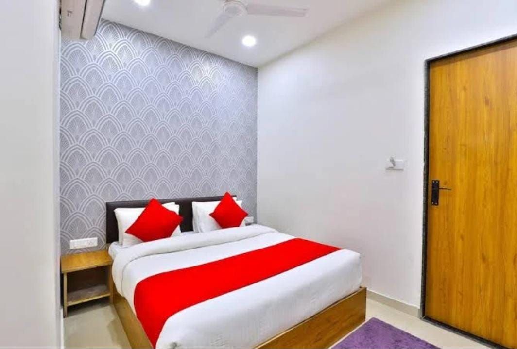 Een slaapkamer met een bed, een houten deur en een behang met patroon.