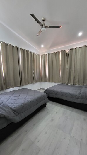A bedroom with two beds, a ceiling fan, and curtains. - Rancho El Venado Termales (Acatic)