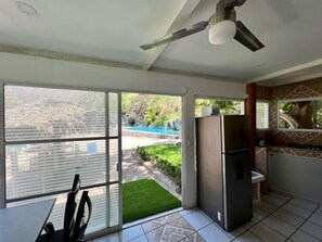 A kitchen with a refrigerator, a ceiling fan, and a view of a swimming pool. - Rancho El Venado Termales (Acatic)
