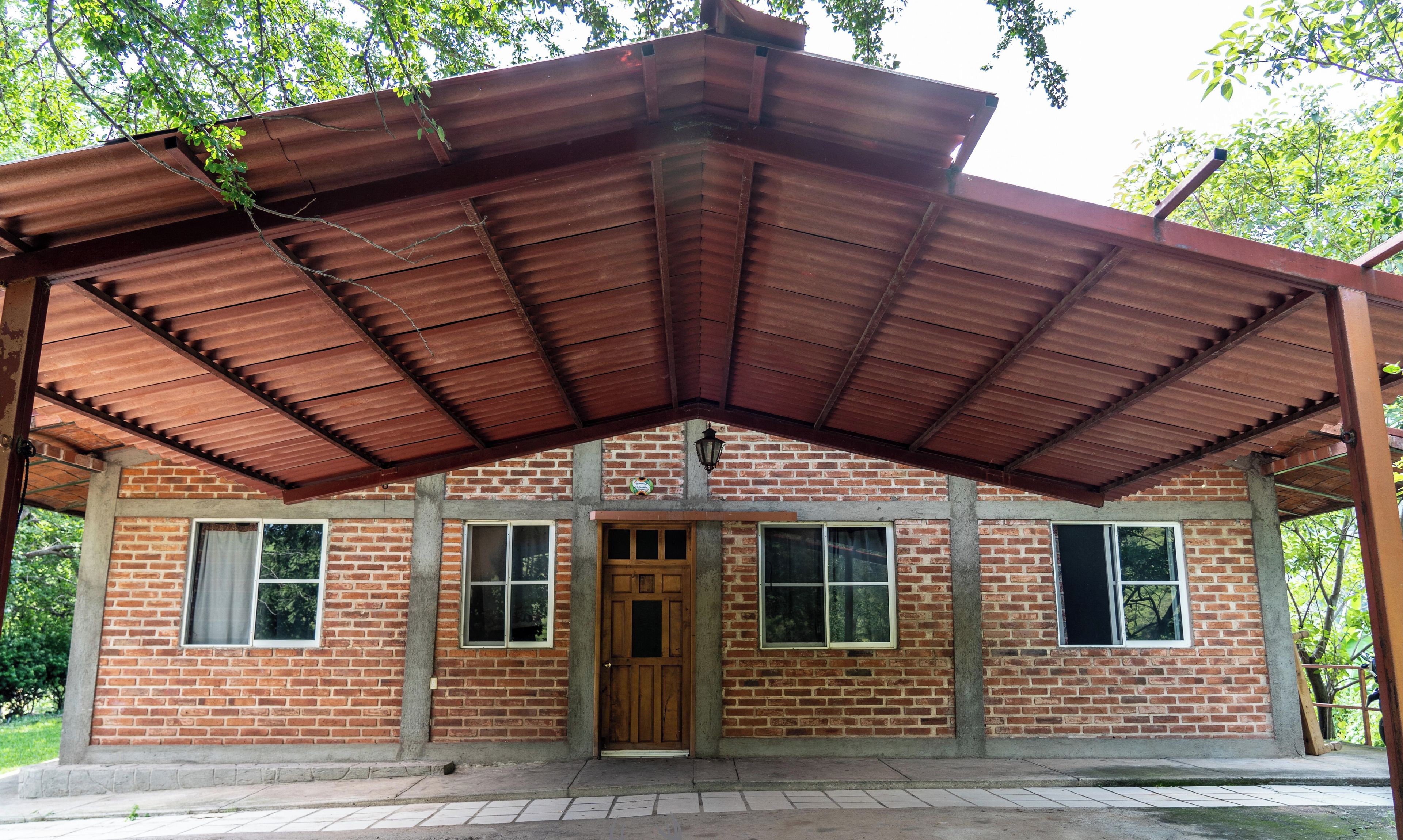 A brick building with a metal roof and a wooden door.