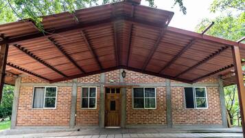 A brick building with a metal roof and a wooden door.