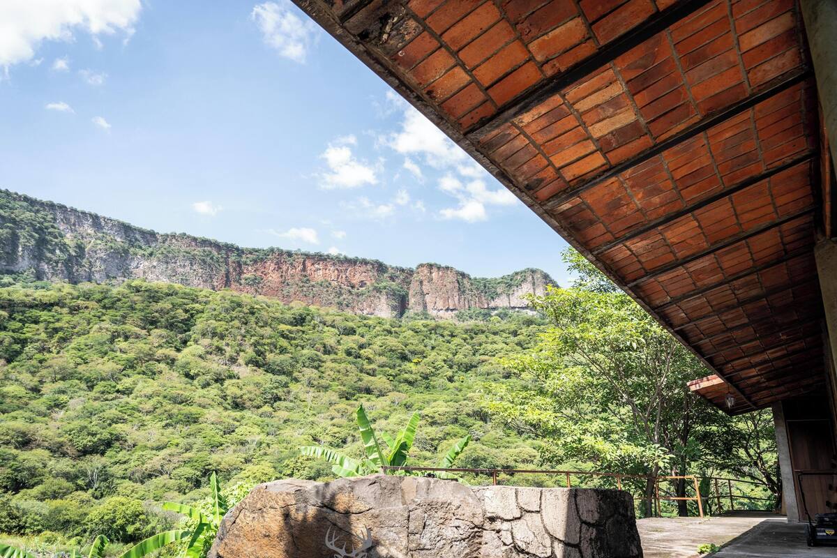 Vista de un paisaje montañoso con una estructura de piedra y techo de madera.
