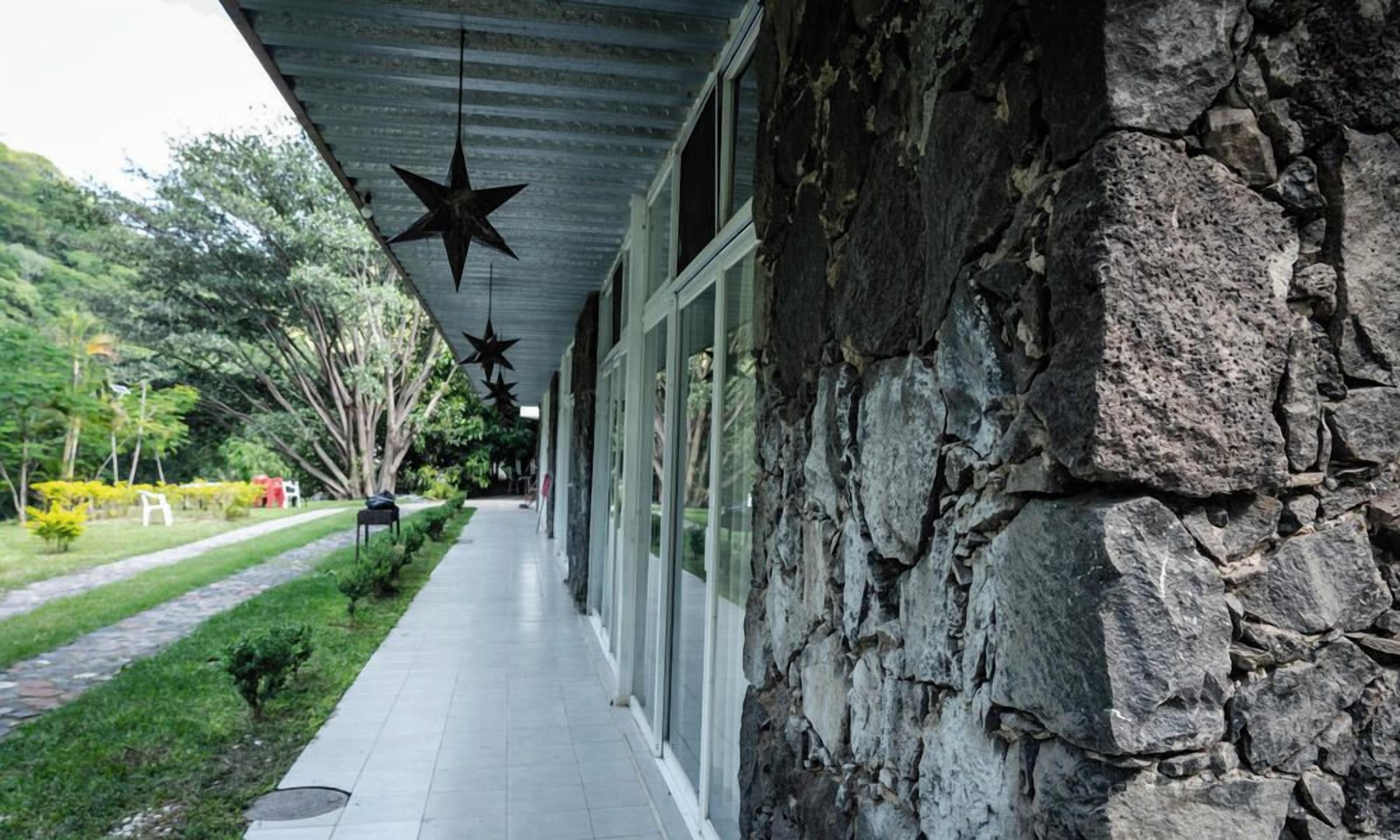 A covered walkway with stone walls and hanging star decorations.