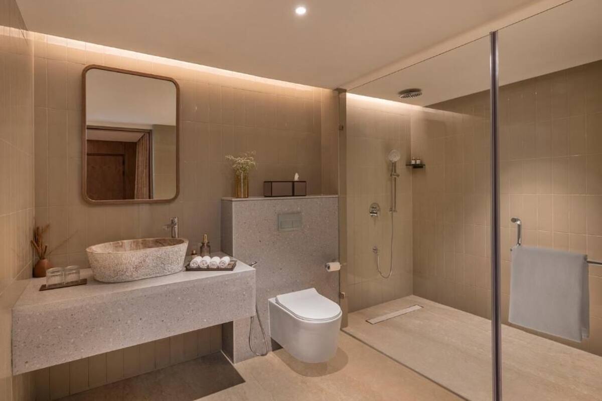 Un baño moderno con una bañera independiente, un inodoro y una zona de ducha con mampara de vidrio.