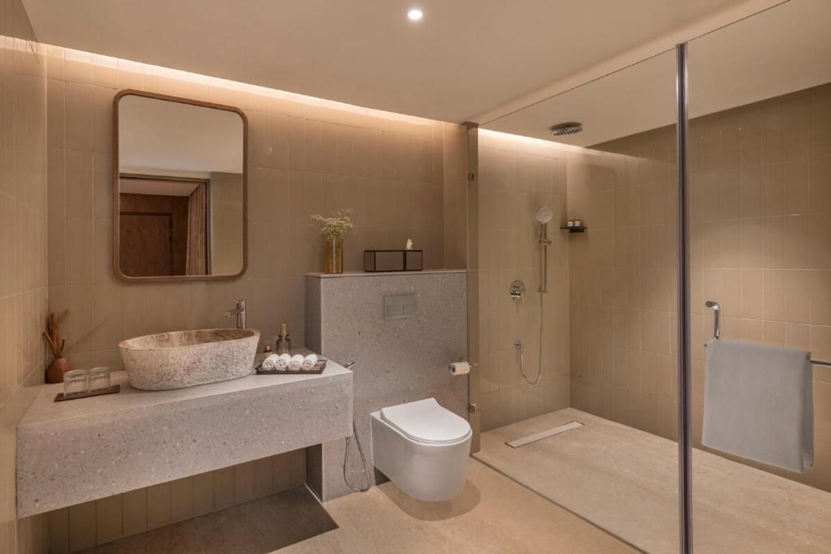 A modern bathroom with a freestanding bathtub, a toilet, and a glass-enclosed shower area.