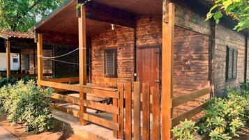 Eine Holzhütte mit Veranda, einer Tür und einem Fenster.