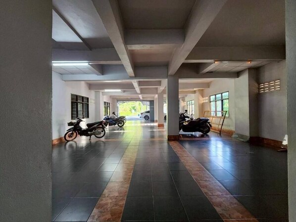 A corridor with tiled flooring, concrete pillars, and windows allowing natural light. - Saan Stay (Krabi)
