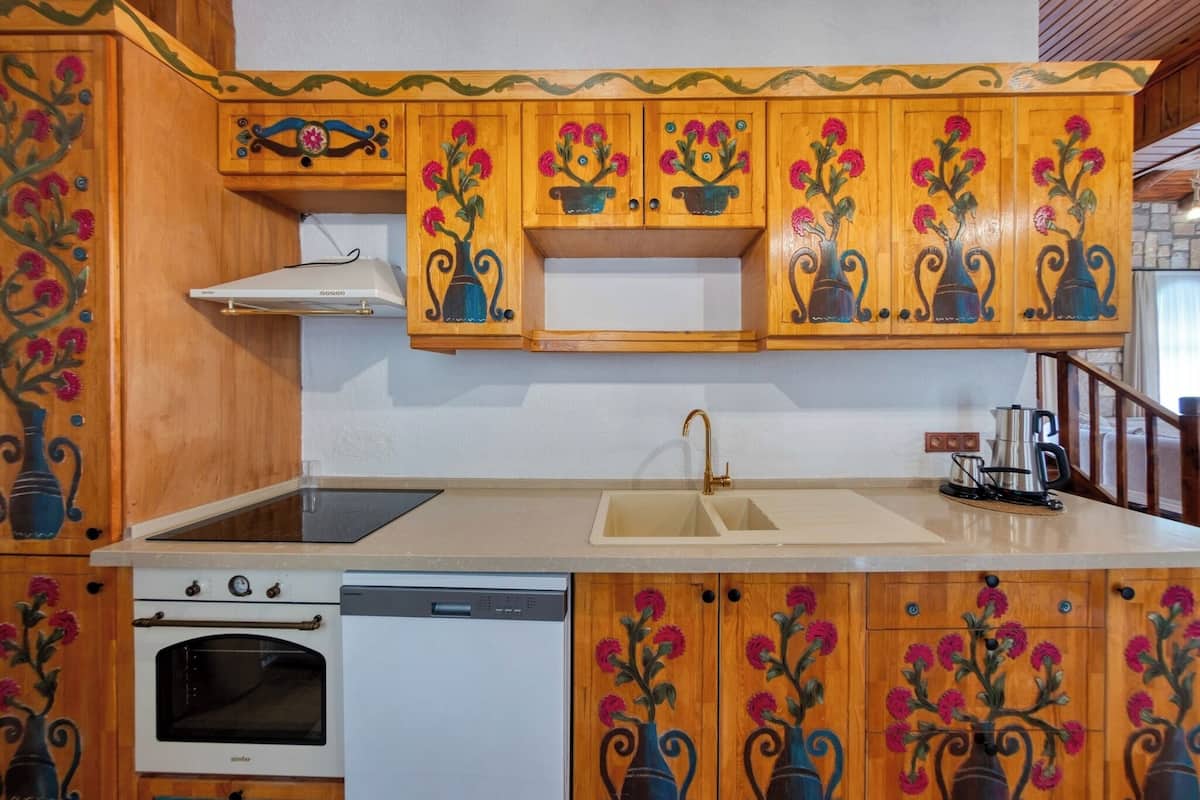A kitchen with wooden cabinets, a sink, a stove, and a dishwasher.