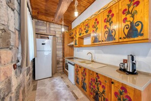 A kitchen with wooden cabinets, a white refrigerator, and a sink. - Taş Mahal Fethiye (Fethiye)