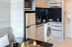 A modern kitchen with a microwave, stove, and washing machine. - Apprtem Zoal (Casablanca)