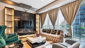 A modern living room with a large flat-screen TV, plush seating, and a fireplace. - High End Holiday Homes (Dubai)