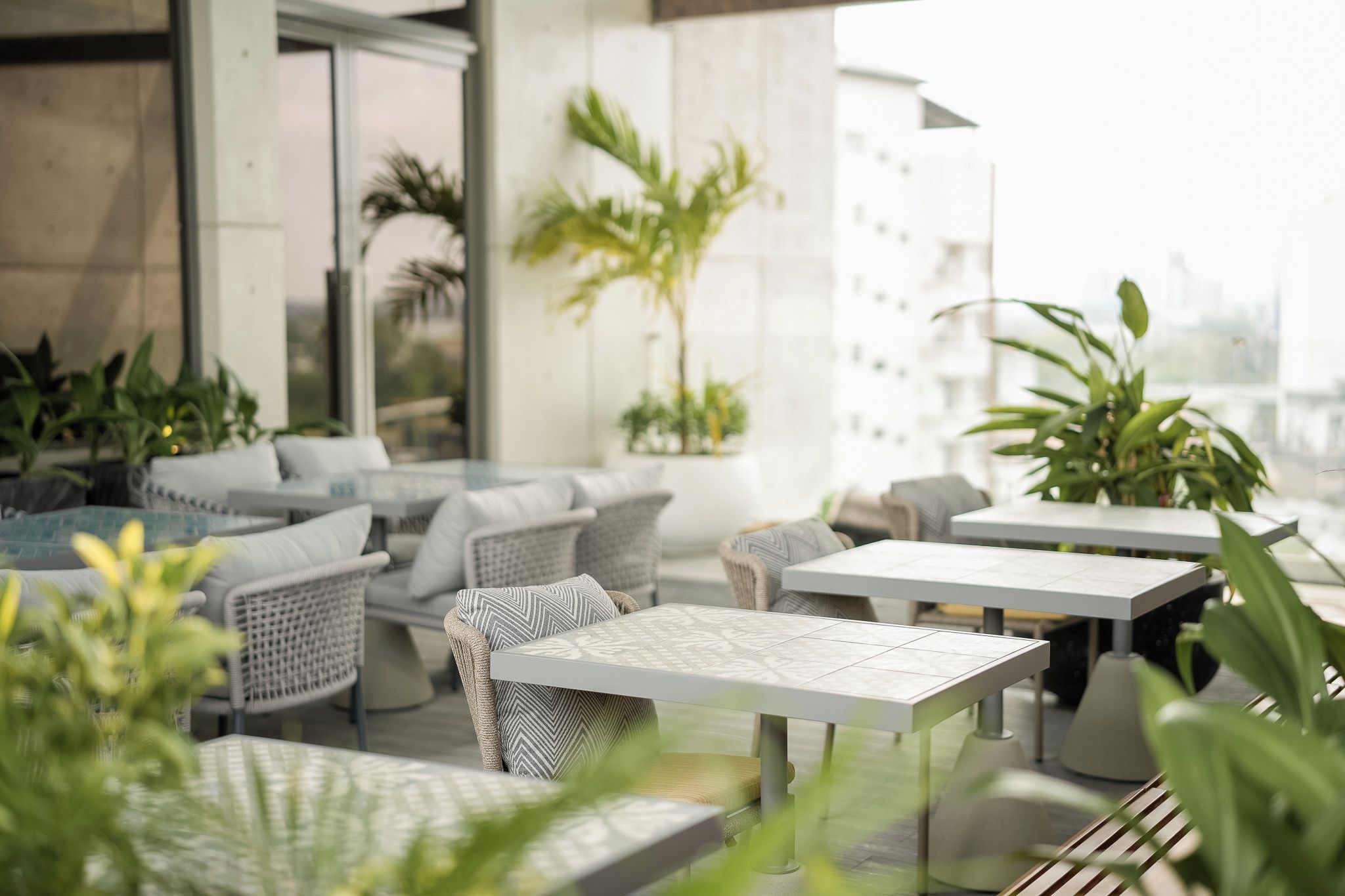 An outdoor seating area with wicker furniture and potted plants.