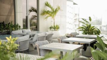An outdoor seating area with wicker furniture and potted plants.