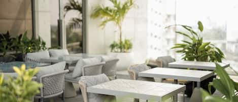 An outdoor seating area with wicker furniture and potted plants.