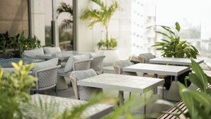 An outdoor seating area with wicker furniture and potted plants. - Sesaya Poshtel & Bistro (Sri Jayawardenepura Kotte)