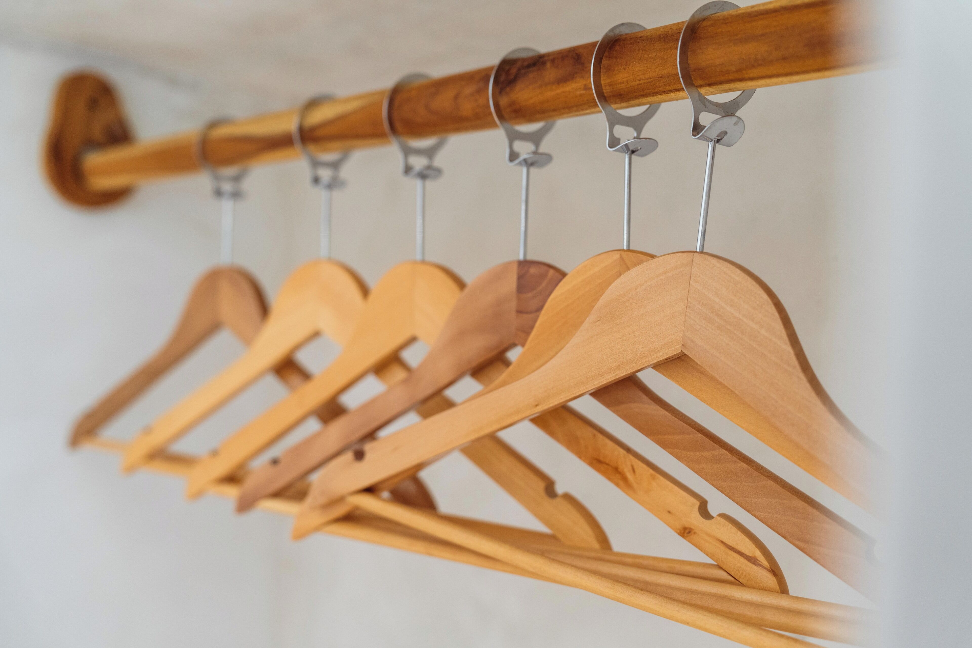 A wooden coat rack with multiple hangers.