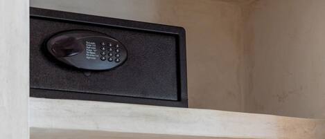 Un porte-manteau en bois, muni de cintres, et un appareil électronique noir placé au-dessus.