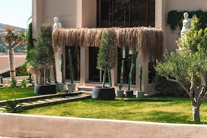 A building with a thatched roof, potted cacti, and a statue. - L'saranda House Cesme (Çeşme)