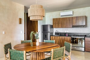 A modern kitchen with wooden cabinets, a stainless steel refrigerator, and a built-in oven. - Amina Wind Resort (La Ventana)