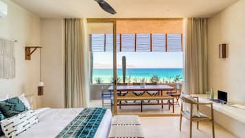 Ein Schlafzimmer mit Bett, Schreibtisch, Stuhl und Meerblick.