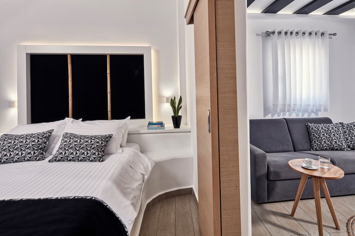 Quarto moderno com cama, mesa de cabeceira e planta em vaso.