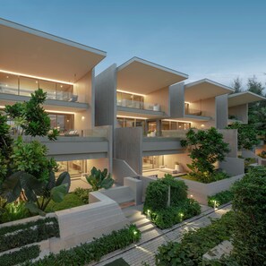 A modern multi-story building with balconies, outdoor seating, and lush greenery.