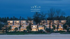 A modern multi-story residential building with multiple balconies, surrounded by trees and a beach. - Veyla Natai Residences (Takua Thung)