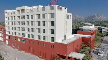 Un edificio de varios pisos con techo plano y fachada roja y blanca.