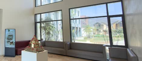 A spacious lobby with large windows, a reception desk, and a decorative centerpiece.