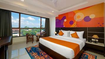 Habitación de hotel con una cama grande, un escritorio, una silla, vistas a la ciudad y un diseño de pared colorido.