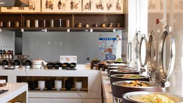 Uma área de buffet com diversos pontos de comida e seleção de bebidas.