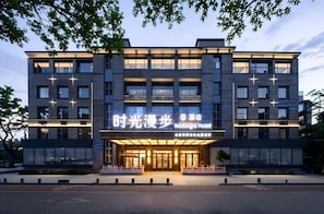 A modern hotel with a prominent entrance, multiple floors, and a sign indicating it is the Nostalgia Hotel. - Nostalgia S Hotel(beijing Tianqiao (Beijing)