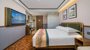 A hotel room with a bed, a desk, a chair, a mirror, and a wall-mounted TV. - Nostalgia S Hotel(beijing Tianqiao (Beijing)