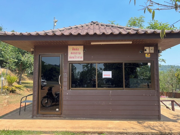 Un petit bâtiment avec un toit en tuiles, une porte et une fenêtre.