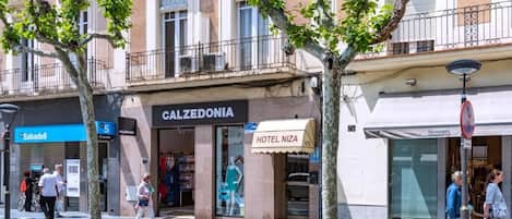 Straßenansicht mit einem Hotel namens 'Calzedonia' und dem Hotel 'Niza' auf der gegenüberliegenden Straßenseite.