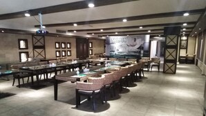 Una amplia sala de conferencias con una larga mesa y sillas, un proyector y un cartel que dice "SULBIN".